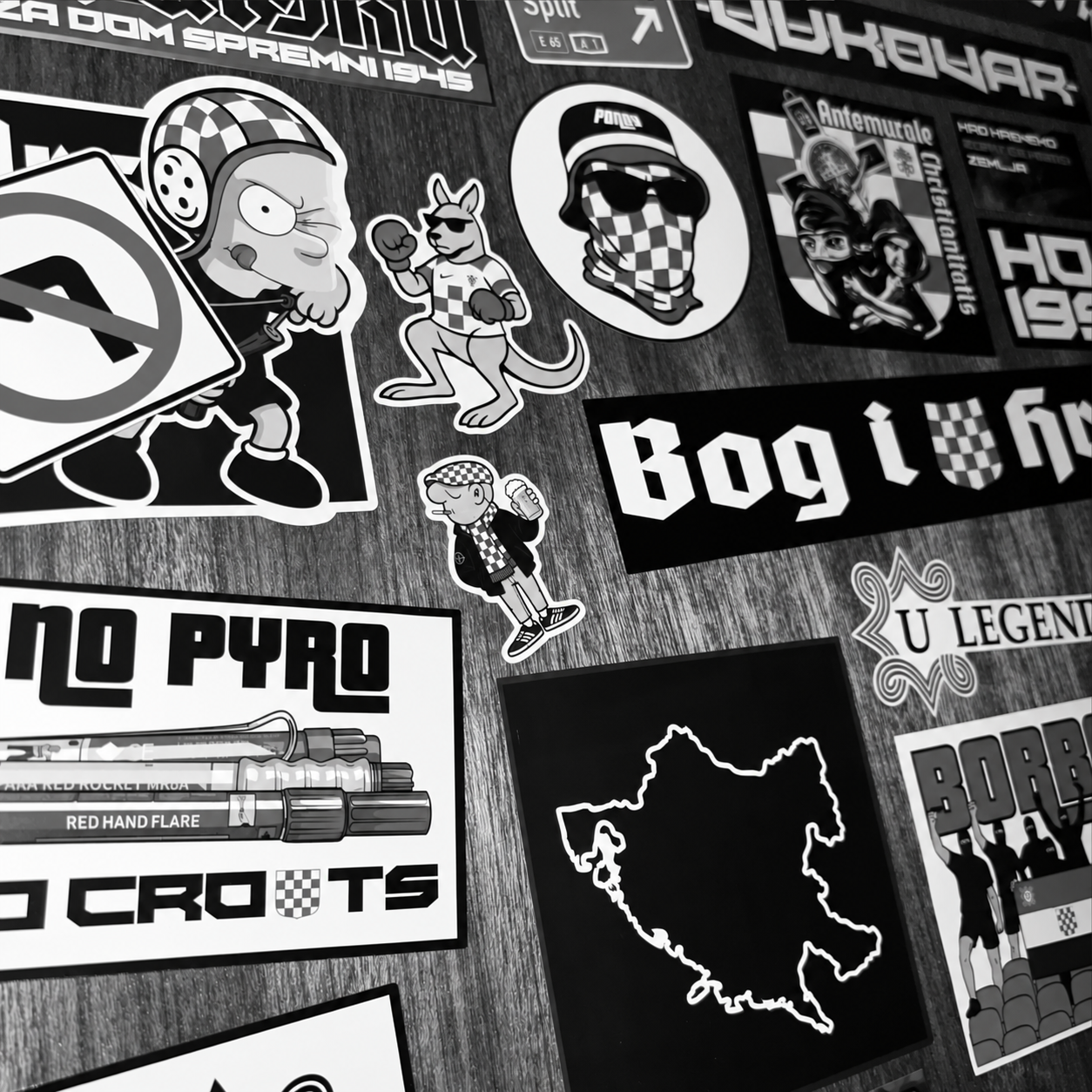Black-and-white archive photograph of Volume I stickers arranged on a wooden surface